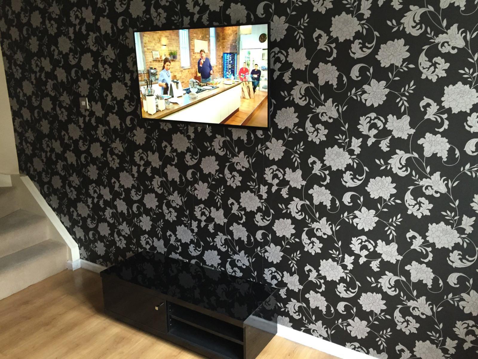 TV wall mounted against feature floral wallpaper with hidden wiring