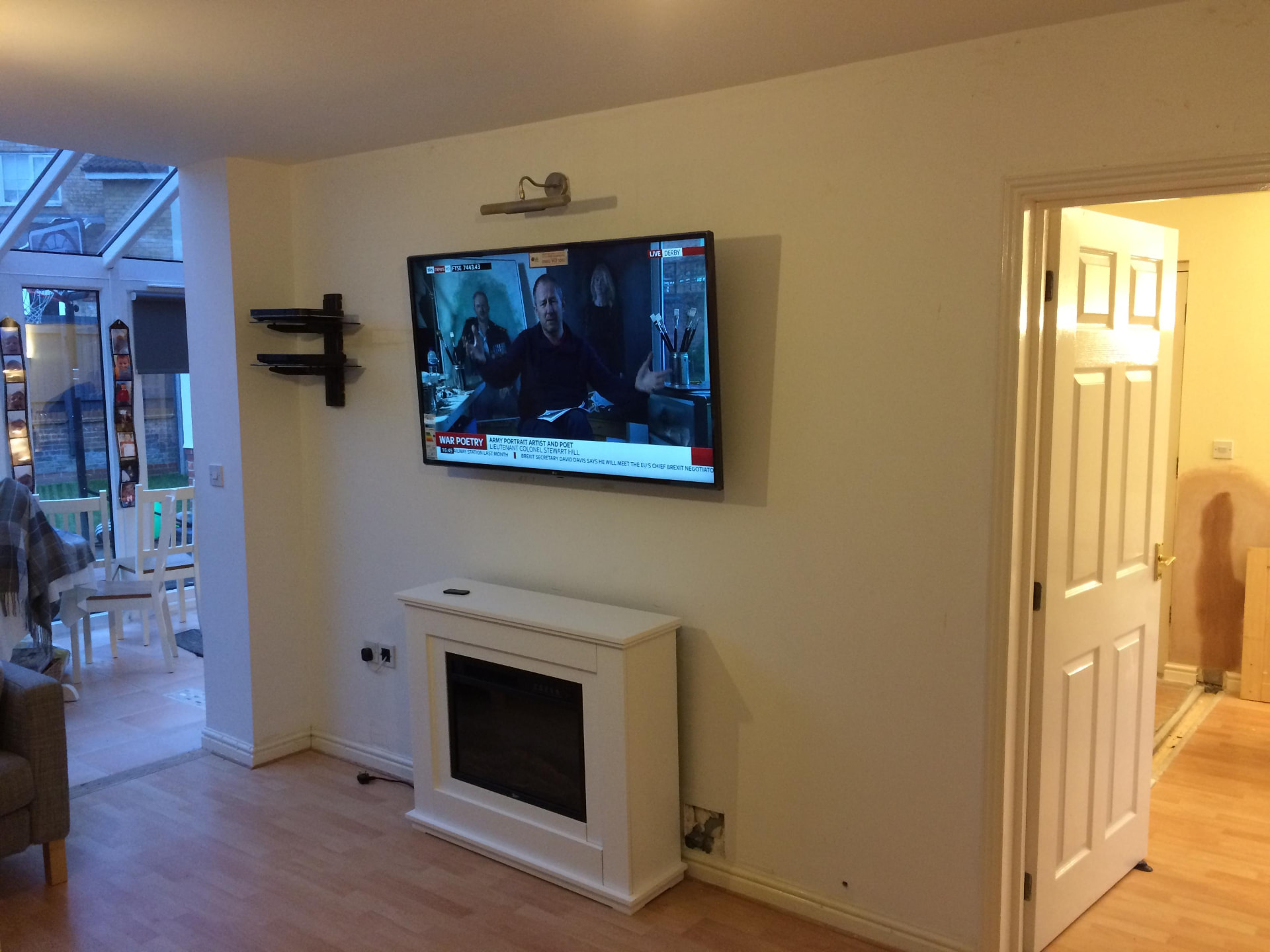 TV wall mounted above an electric fireplace with concealed cabling
